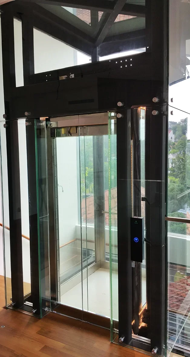 Glasaufzug mit dunklem Stahlrahmen im Innenraum eines Wohnhauses