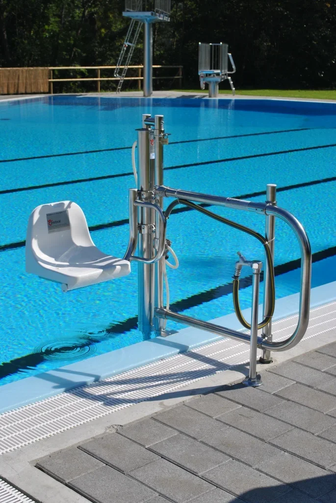 Poollift mit wei&szlig;em Sitz am Schwimmbecken eines Freibads