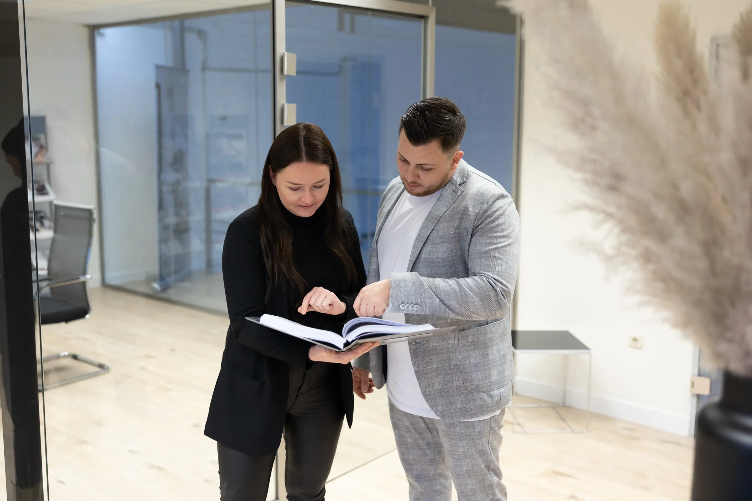 Zwei Mitarbeitende von ALPHA Aufzugsservice besprechen Unterlagen im B&uuml;ro