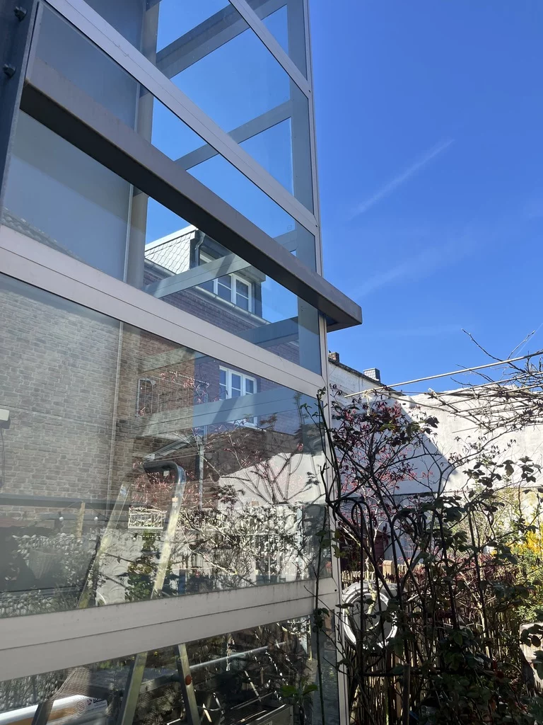 Verglaster Außenschacht eines Homelifts an der Hausfassade, Blick nach oben