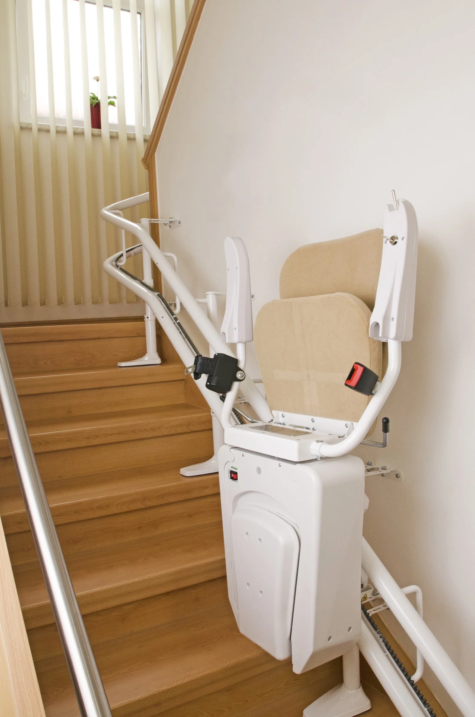 Zusammengeklappter Sitztreppenlift an einer geraden Holztreppe