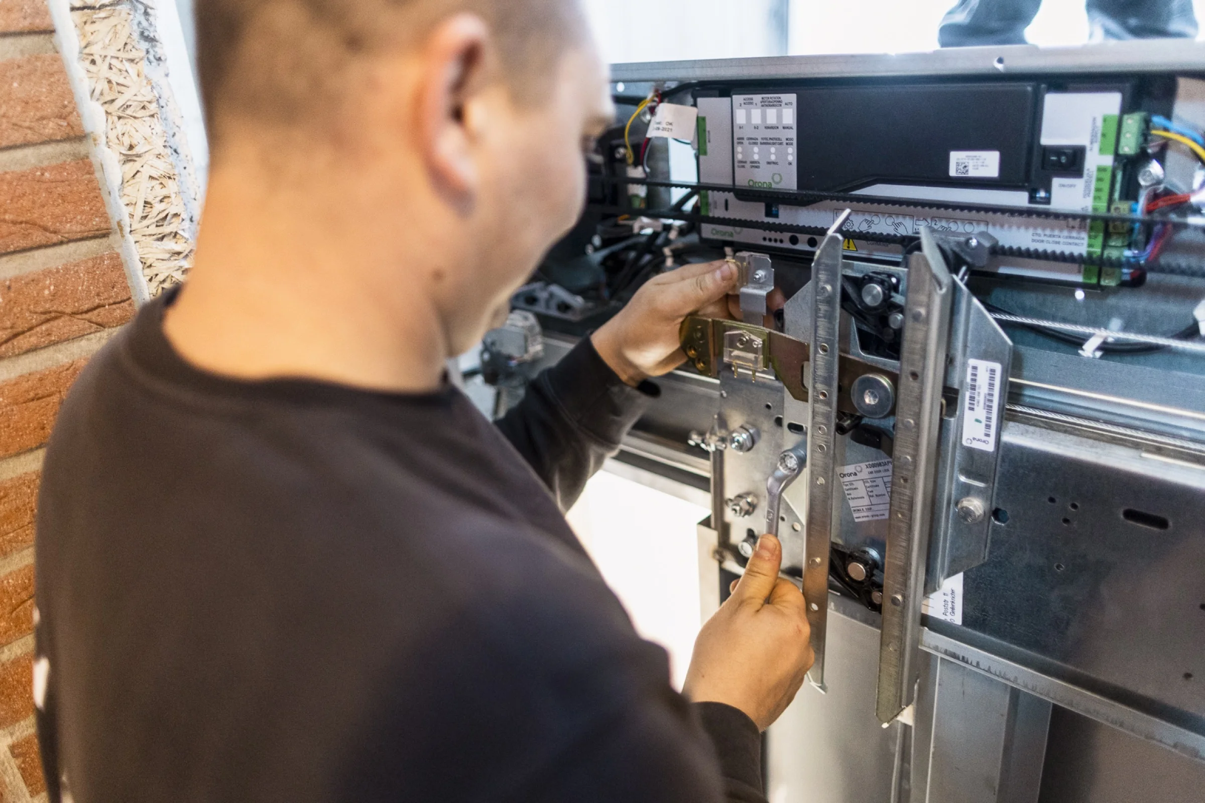 Techniker von ALPHA Aufzugsservice justiert die Türmechanik eines Aufzugs