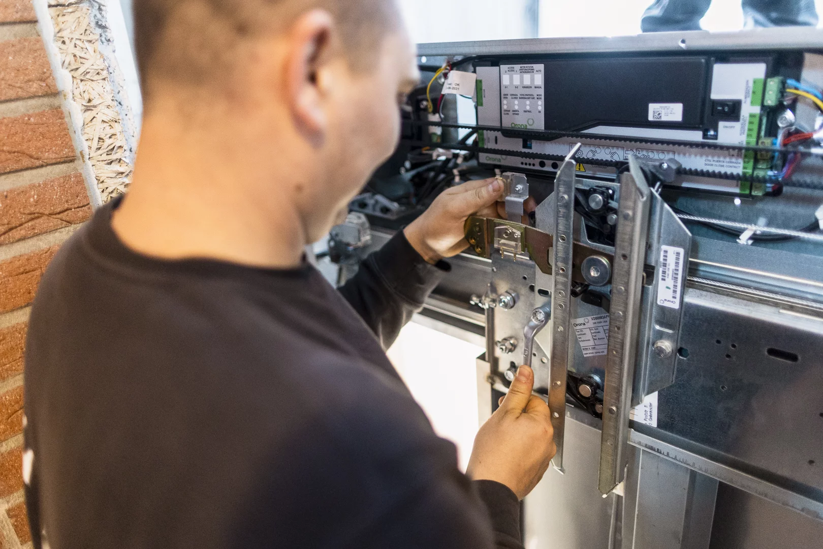 Techniker von ALPHA Aufzugsservice justiert die Türmechanik eines Aufzugs